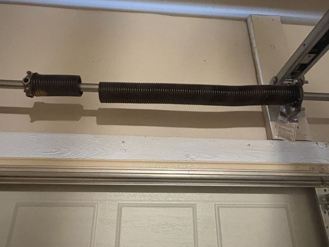 Garage door torsion spring showing damage